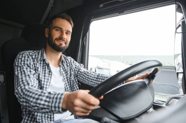 Kamyon kabininde direksiyon başında.