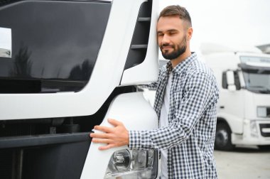 Kamyon şoförü işini seviyor. Profesyonel kamyon şoförü. Kamyon kulübesine sarılıyor. İşini seviyor.