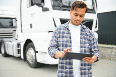 Minibüste tablet kullanan mutlu Hint kuryesi. Yüksek kalite fotoğraf.