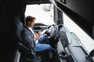 Genç Hintli bir erkek kamyon şoförü direksiyonda oturuyor..