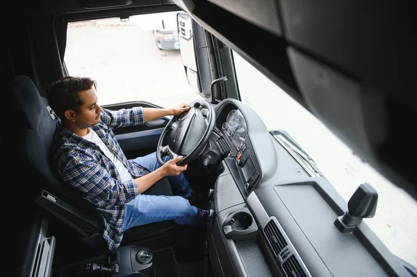 若いインドの男性トラック運転手が車輪の後ろに座る ストックフォト