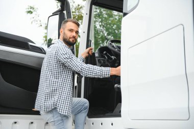 Kamyon şoförü yarı kamyonun taksisine biniyor..