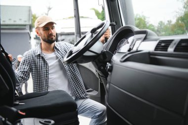 Kamyon şoförü yarı kamyonun taksisine biniyor..