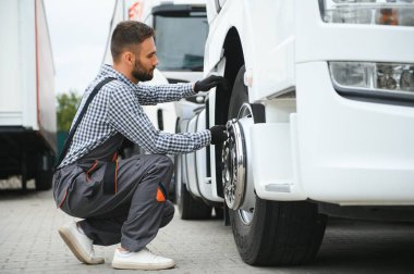 Hasarlı lastik. Genç kamyon şoförü gündüz vakti aracıyla geliyor..
