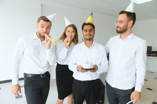 Surprise. Mixed race happy people celebrating a birthday of colleague in the modern office.