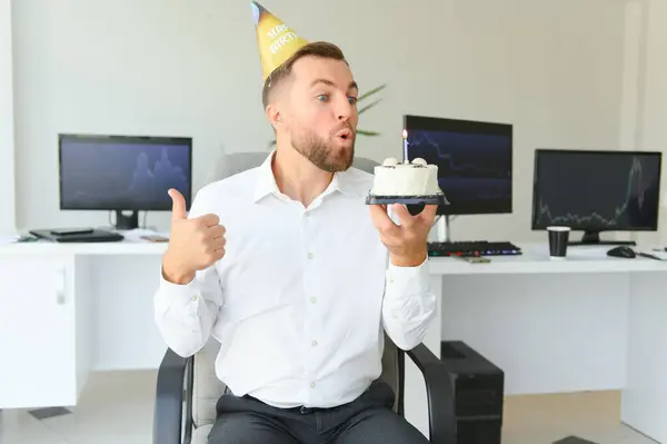 年轻快乐的商人在办公室里庆祝他的生日 他手里拿着一个蛋糕 — 图库照片