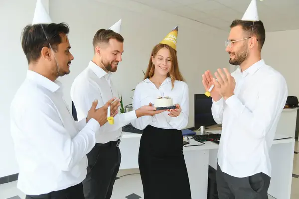 Business team celebrating a birthday of collegue in the modern office