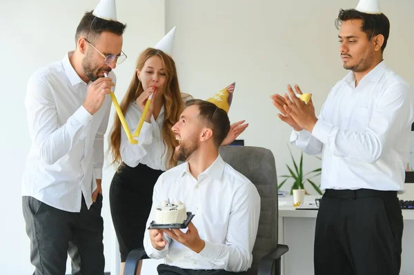 corporate party and people concept - happy team with cake celebrating colleague birthday at office.