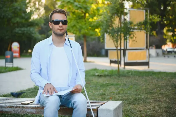 Blinded man reading by touching braille book.