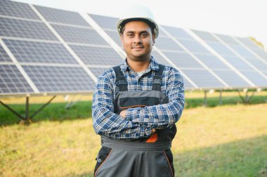 Erkek Arap mühendis güneş panellerindeki direnci kontrol ediyor. İstasyonda çalışan Hintli adam..