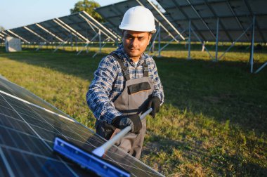 Hintli işçi güneş panellerini temizliyor.