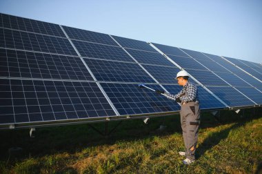 Hintli işçi güneş panellerini temizliyor.