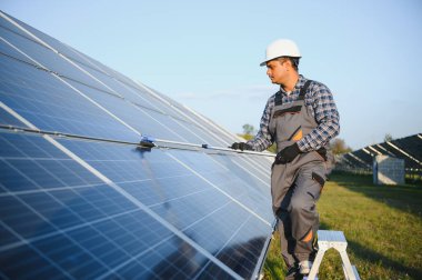 Hintli işçi güneş panellerini temizliyor.
