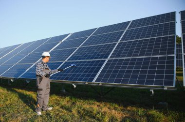 Hintli tamirci güneş panellerini temizleyip toz ve kir oluşturuyor..