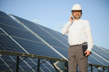 Solar power plant. Man standing near solar panels. Renewable energy.