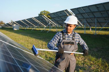 Hintli tamirci güneş panellerini temizleyip toz ve kir oluşturuyor..