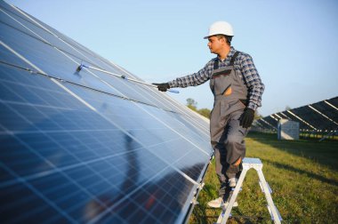 Hintli tamirci güneş panellerini temizleyip toz ve kir oluşturuyor..