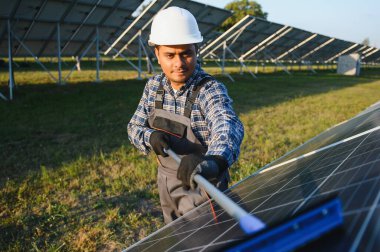 Hintli tamirci güneş panellerini temizleyip toz ve kir oluşturuyor..