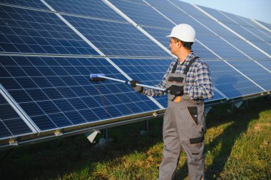 Hintli işçi güneş panellerini temizliyor.