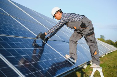 Erkek Arap mühendis güneş panellerindeki direnci kontrol ediyor. İstasyonda çalışan Hintli adam..