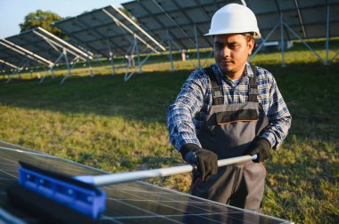 Hintli tamirci güneş panellerini temizleyip toz ve kir oluşturuyor..