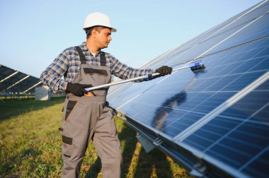 Hintli işçi güneş panellerini temizliyor.