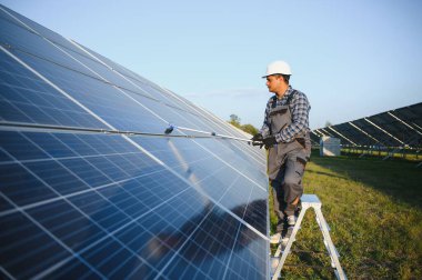 Hintli işçi güneş panellerini temizliyor.