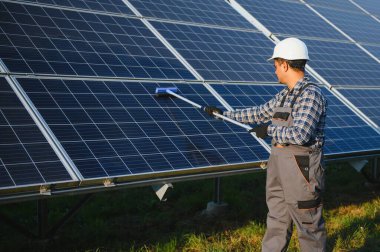 Hintli tamirci güneş panellerini temizleyip toz ve kir oluşturuyor..