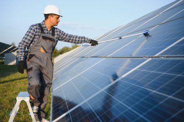 Hintli tamirci güneş panellerini temizleyip toz ve kir oluşturuyor..