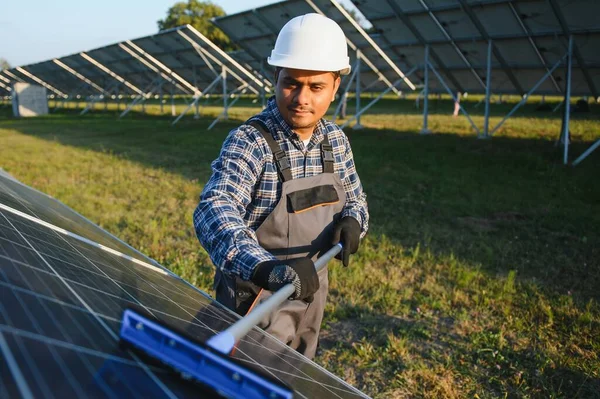 Hintli işçi güneş panellerini temizliyor.