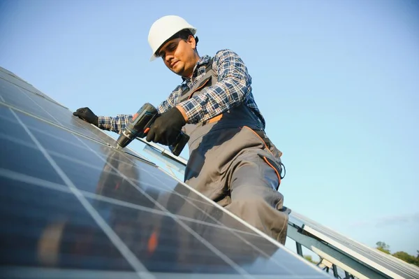 An Indian worker installs solar panels. The concept of renewable energy
