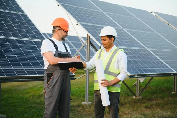 The solar farm(solar panel) with two engineers walk to check the operation of the system, Alternative energy to conserve the world\'s energy, Photovoltaic module idea for clean energy production.