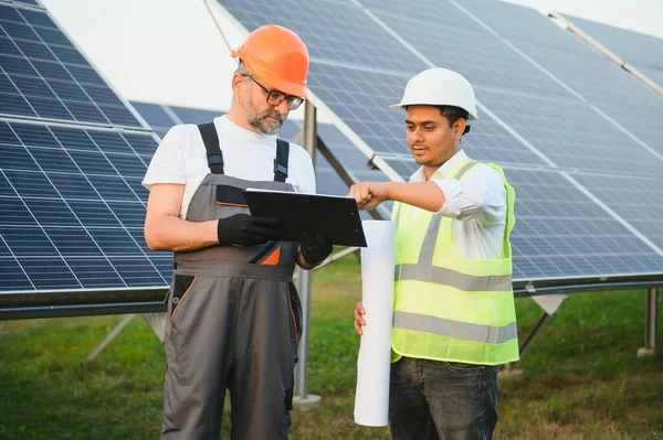 The solar farm(solar panel) with two engineers walk to check the operation of the system, Alternative energy to conserve the world\'s energy, Photovoltaic module idea for clean energy production.