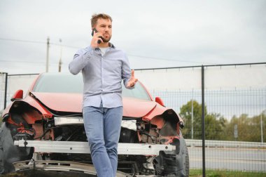 Adam yolda bir araba kazasında kaza sonrası yardım arıyor.