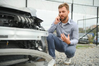 Adam yolda bir araba kazasında kaza sonrası yardım arıyor.