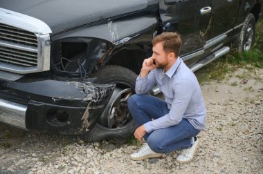 Adam yolda bir araba kazasında kaza sonrası yardım arıyor.