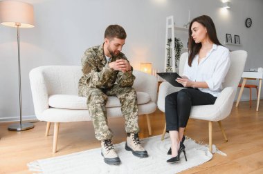 Psikolog üzgün erkek asker, Ptsd ile terapi oturumu sırasında notlar yapma.