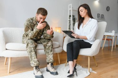 Ofisteki psikologla randevusu olan üzgün erkek asker..