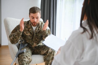 Psikolog üzgün erkek asker, Ptsd ile terapi oturumu sırasında notlar yapma.