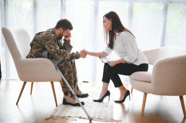 Psikolog üzgün erkek asker, Ptsd ile terapi oturumu sırasında notlar yapma.
