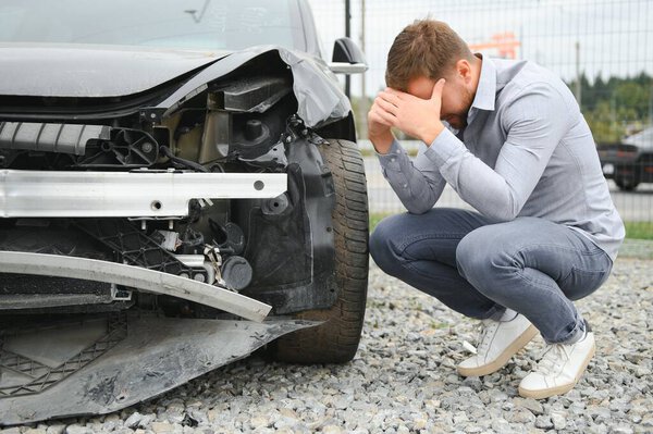Автокатастрофа. Человек после автомобильной аварии. Человек сожалеет об ущербе, причиненном во время аварии.