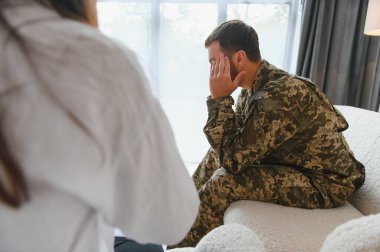 Ofisteki psikologla randevusu olan üzgün erkek asker..