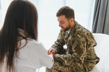 Psikolog üzgün erkek asker, Ptsd ile terapi oturumu sırasında notlar yapma.