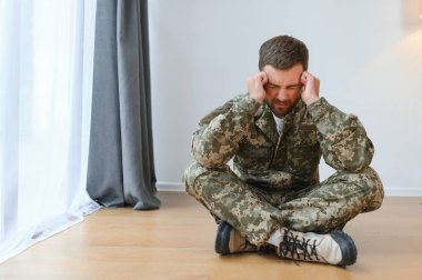 Orta yaşlı, çaresiz bir askerin portresi. Travma sonrası stres bozukluğu. Yatay çekim.