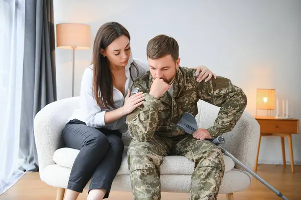 A wife supports a sad military husband who has health problems after returning home from the war.