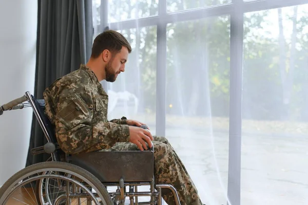Unhappy military man sitting in wheelchair