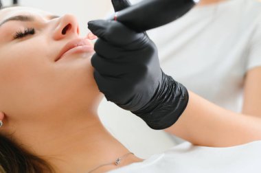 Kalıcı makyaj güzellik salonda dudaklarında sahip genç kadın.