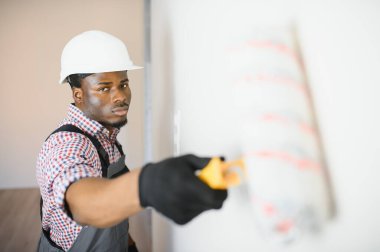 Afro-Amerikalı ressam odada tamirat yapıyor..