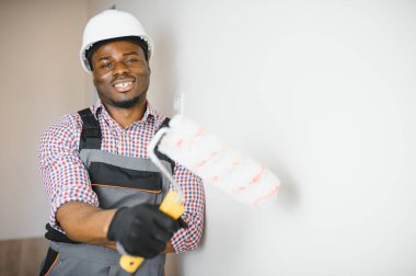 Afro-Amerikalı dekoratör ışık duvarı boyuyor.