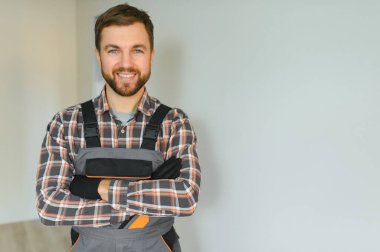 İnşaat alanında çalışırken genç ve yakışıklı bir inşaatçının portresi.